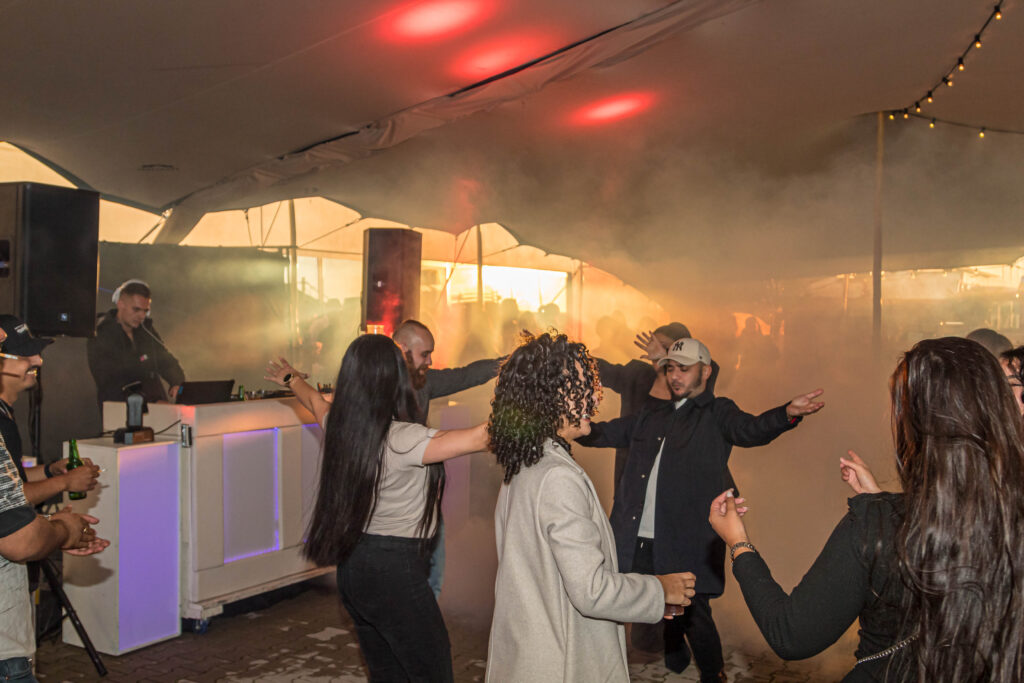 Mensen dansen in een feesttent.