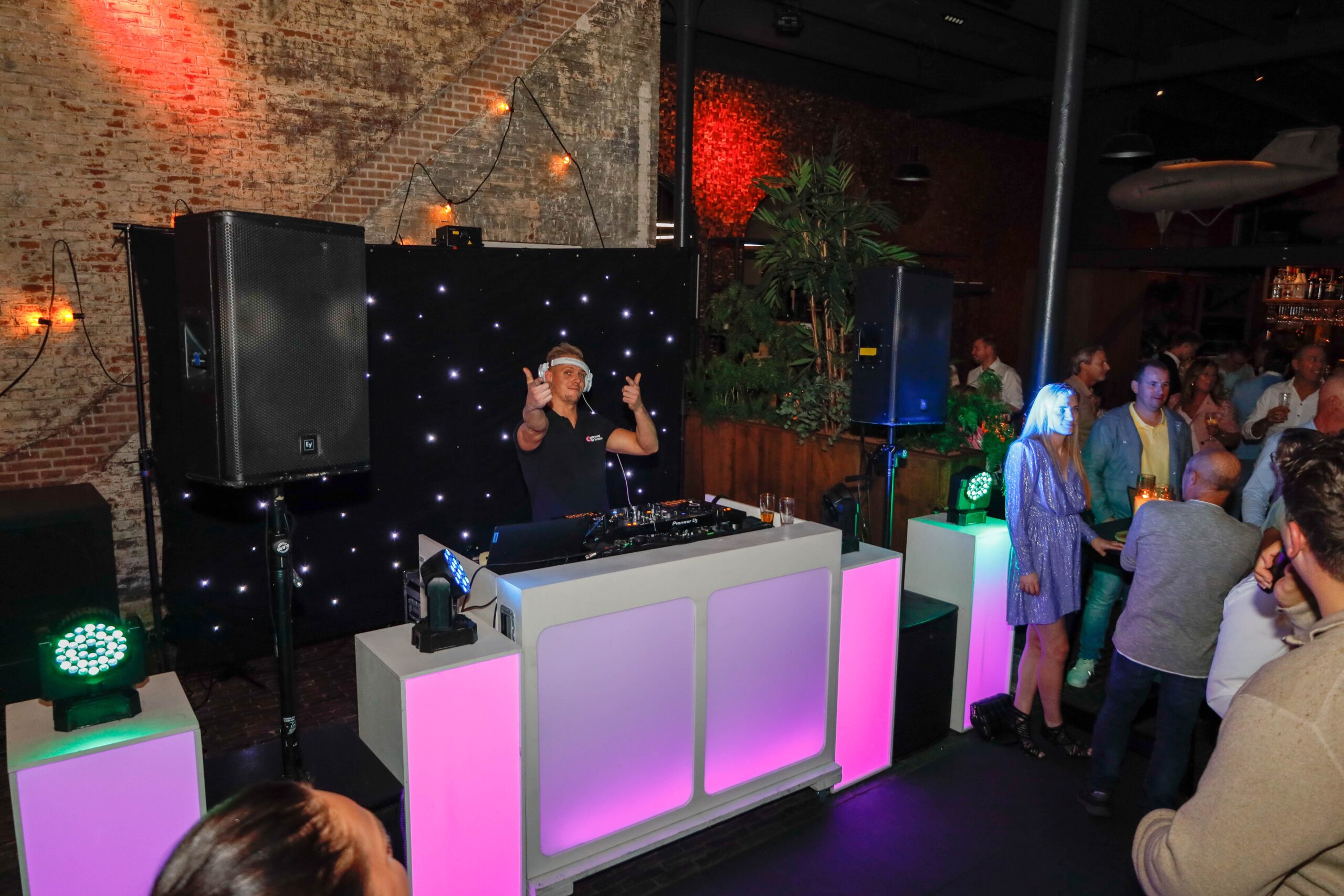 Opening bedrijfspand 22 Dj draait muziek op een feest