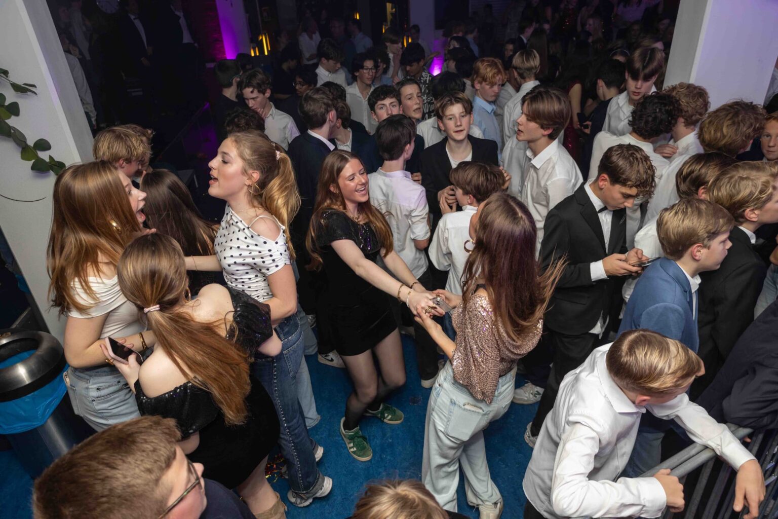 Drukke dansvloer op schoolfeest.