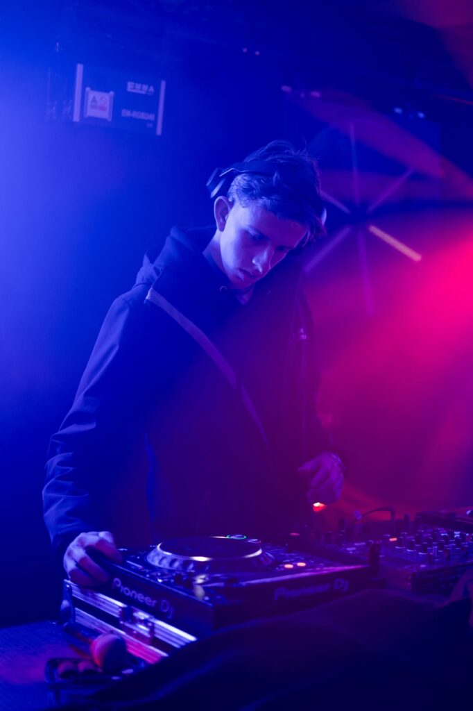 Schoolfeest 11 Dj draait muziek in kleurrijke lichten.