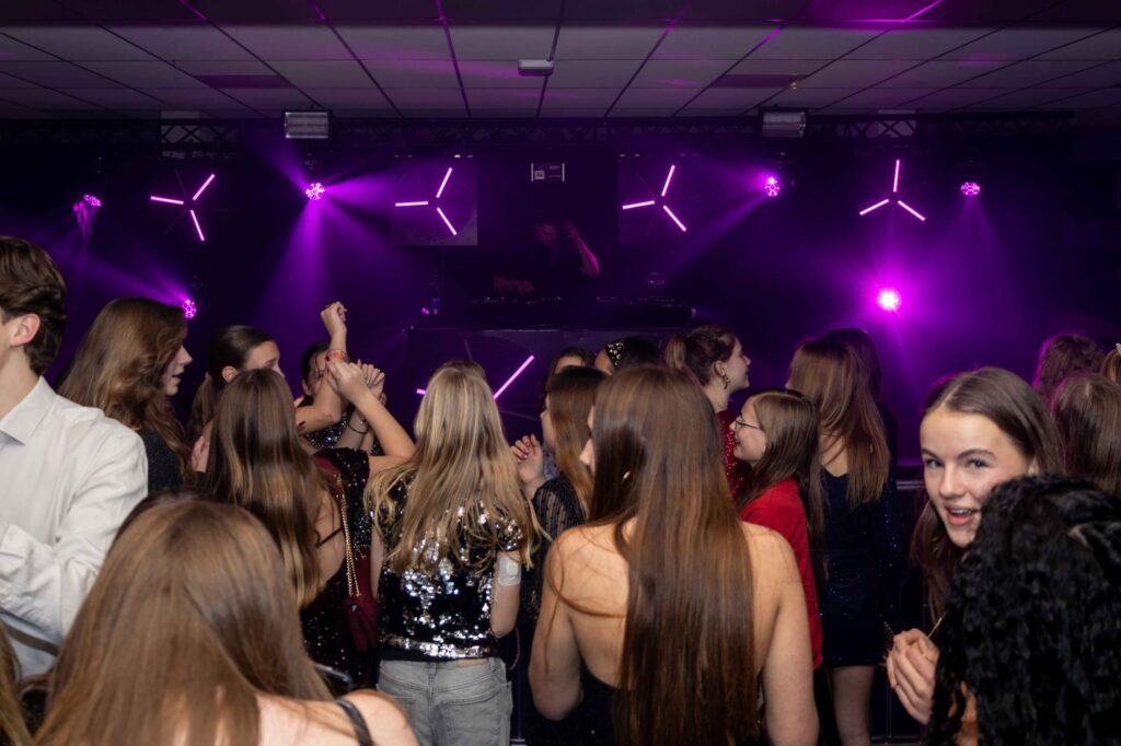 Feestende mensen met dansende lichten tijdens een gala of kerstfeest.